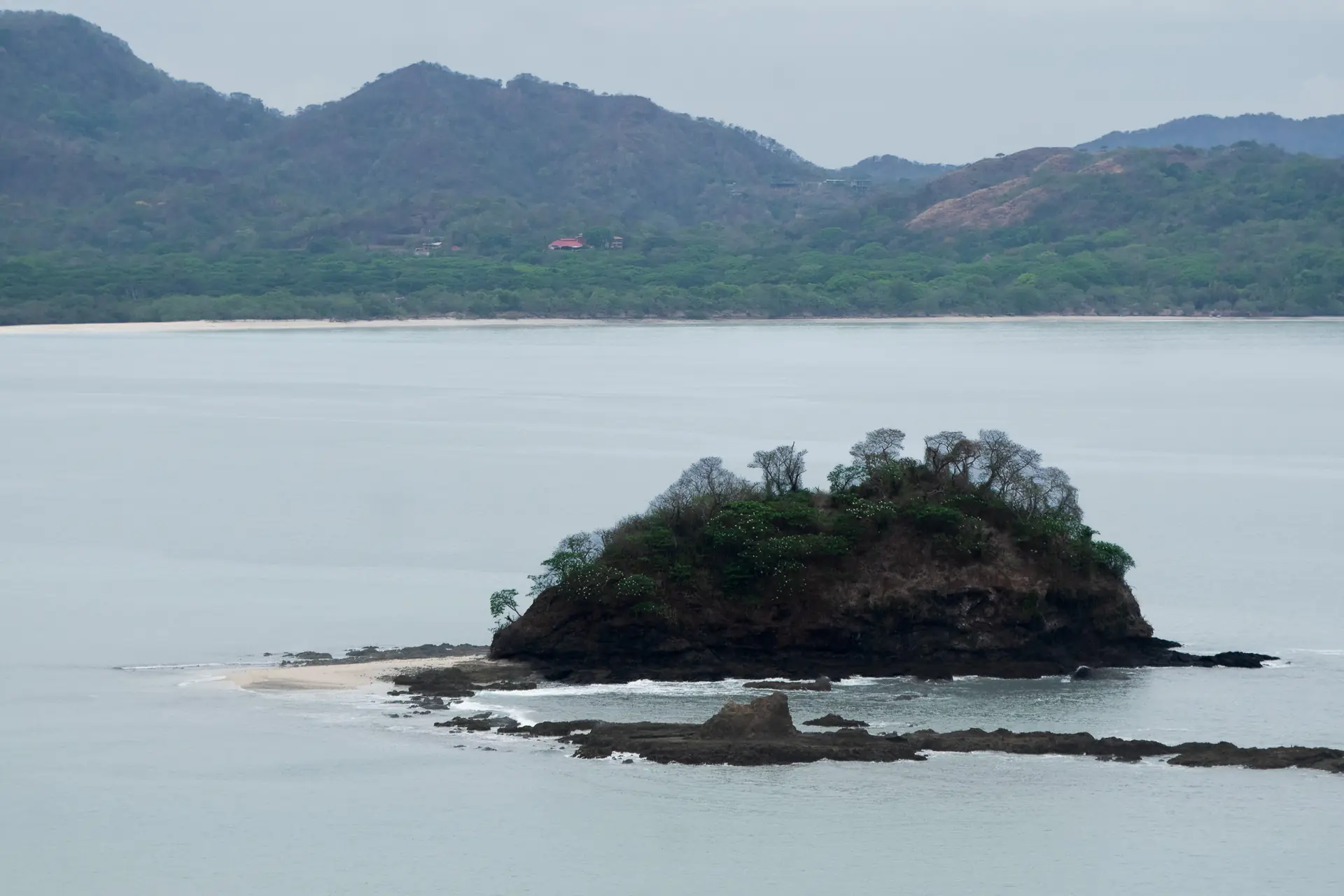 Small forested island in a calm Guanacaste bay